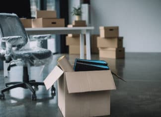 cardboard box with folders and office supplies in floor during relocation